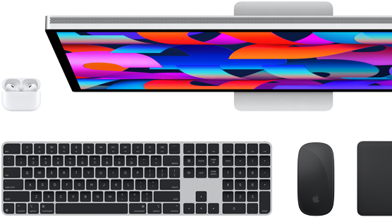 Un monitor Studio Display mostrato dall’alto insieme a una tastiera Magic Keyboard nera, un Magic Mouse nero, un Magic Trackpad nero e una custodia per AirPods bianca